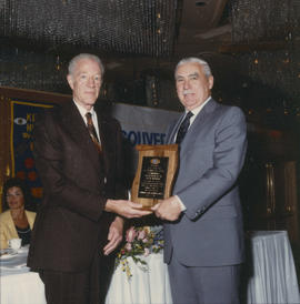 Robert Gordon Rogers delivering plaque to man at Kiwanis Club Centennial luncheon