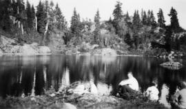 Five hikers resting at a lake