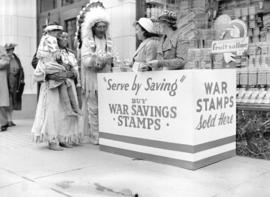 [Stoney Indians buying war savings stamps at a war savings booth on the street]