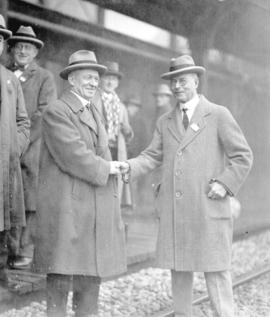 [Mayor L.D. Taylor greeting man at train station]