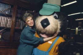 Unidentified woman hugging Tillicum in front of bookcase