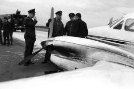 Ministry of Transport personnel standing at forward-end of airplane