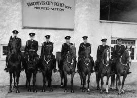 [Vancouver Police Mounted Section group portrait on horseback in front of Squad's department buil...