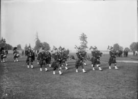 Bagpipers marching in a field