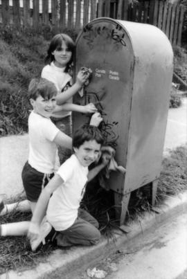 David LeBrun, Troy Zwolinski and Jasmine Gibbons clean graffiti off mailbox