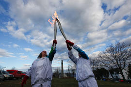Day 12 Torchbearer 5 Gilles Briand passes the flame to Torchbearer 6 Manon LaBillois in Gaspe, Qu...