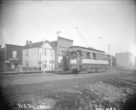 [People hanging on to back of streetcar at Hastings and Carrall Streets]