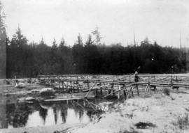 Woman on old footbridge crossing slough at Jericho Golf Club