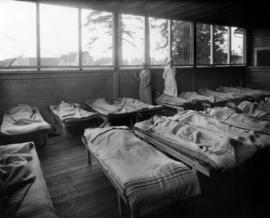 Children laying on cots at Open Air School