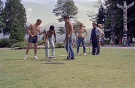 Group of men hammering hardware into ground