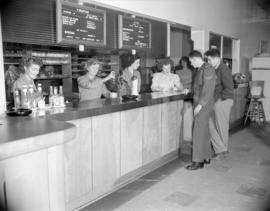 [Two men at the food  service counter at the Vancouver Roller Skating Club]