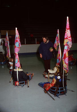 [Woman surrounded by children in ice sledges]