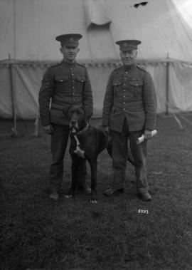 [Two men in uniform with a dog]
