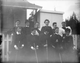 [Women's field hockey team assembled in front of fence at Brockton Point grounds]