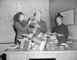 W.C. Mainwaring [holding] books