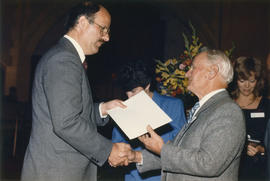 Mike Harcourt shakes hands with unidentified man at St. Andrew's Wesley Church