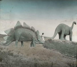 Woman standing between two dinosaur sculptures