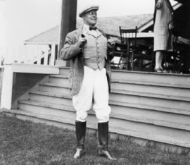 Eric W. Hamber in riding costume holding a pipe