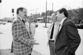 Mike Harcourt speaking with three unidentified men