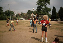 [People playing volleyball at outdoor court]