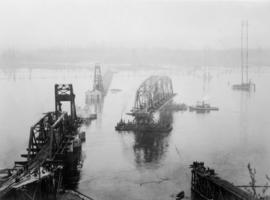 Steel span on scows being floating to position between piers 1 and 2 : April 9, 1925