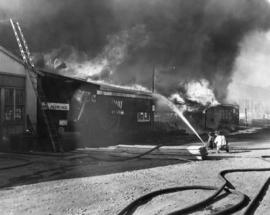 Benson's Shipyard fire [view of firefighter aiming hose at fire]