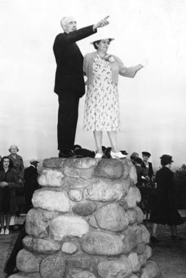 [Mrs. Beatrice Nash and Alex MacDonald stand on cairn at naming ceremony for Queen Elizabeth Park]