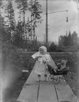 Phyllis Salter standing beside toy carriage