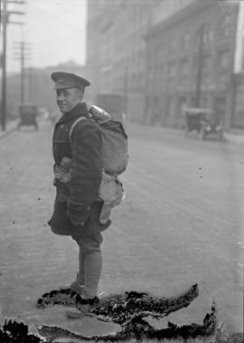 [Soldier with pack and gear in the street]