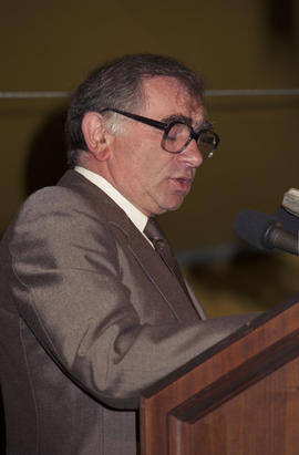 Unidentified man speaking at the lighting of the Peace Flame Monument ceremony