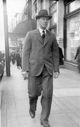 [Unidentified man walking along street]