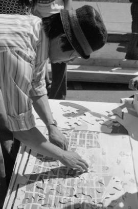 Young man assembling a puzzle at the Habitat Chinatown festival