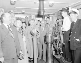 Capt. Caldwell lectures [a group of passengers] on bridge of "Prince George"