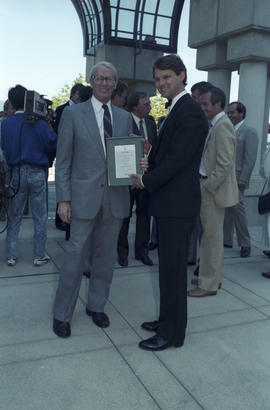 Unidentified man and Gordon Campbell holding framed document at Portal Park opening