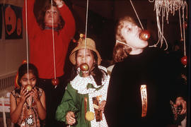 [Children in costumes eating apples on strings at the Mount Pleasant Community Centre]