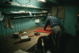 Wing Hing Dry Goods owner Lin Bei-lian working at the cloth cutting table inside his shop