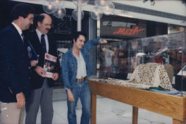 Mike Harcourt and two unidentified men look at display