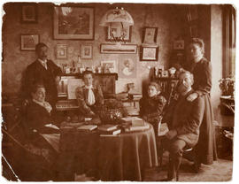 [McCleery family gathered around table in sitting room]