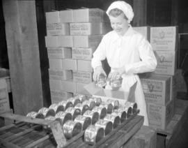 [Woman boxing cans of Hedlund's meat products]