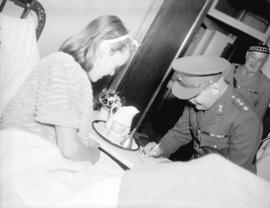 [Lieutenant Governor W.C. Woodward visits a patient in hospital during the] Golden Spike celebration