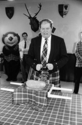 Man wearing kilt standing behind the haggis