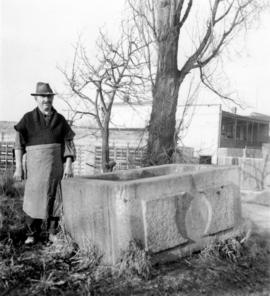 Man standing beside old granite trough in Mount Pleasant