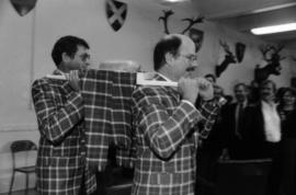 Michael Francis and Mike Harcourt dressed in Centennial tartan carrying the haggis