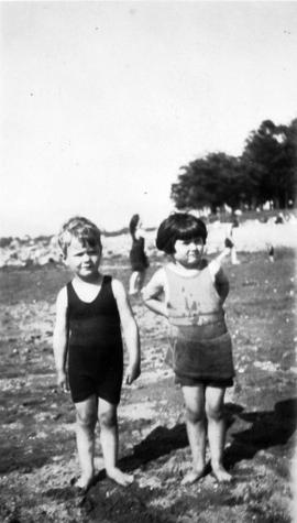 Boy and girl standing in bathing suits at the beach