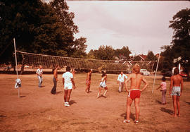 [People playing volleyball on outdoor court]
