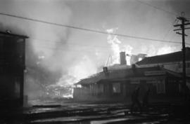 Denman Arena fire with silhouettes of firefighters in the foreground