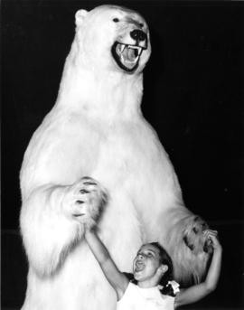 Young girl posing with stuffed polar bear