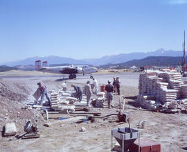 [Crew mixing water with fire control chemicals in large pits and pumping it into a waiting water ...