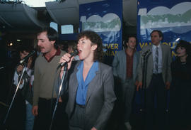 People singing into microphones at Vancouver's 99th birthday celebration