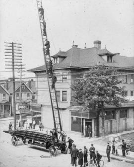 [Firefighters atop aerial ladder in No. 2 Firehall truck on Seymour Street]